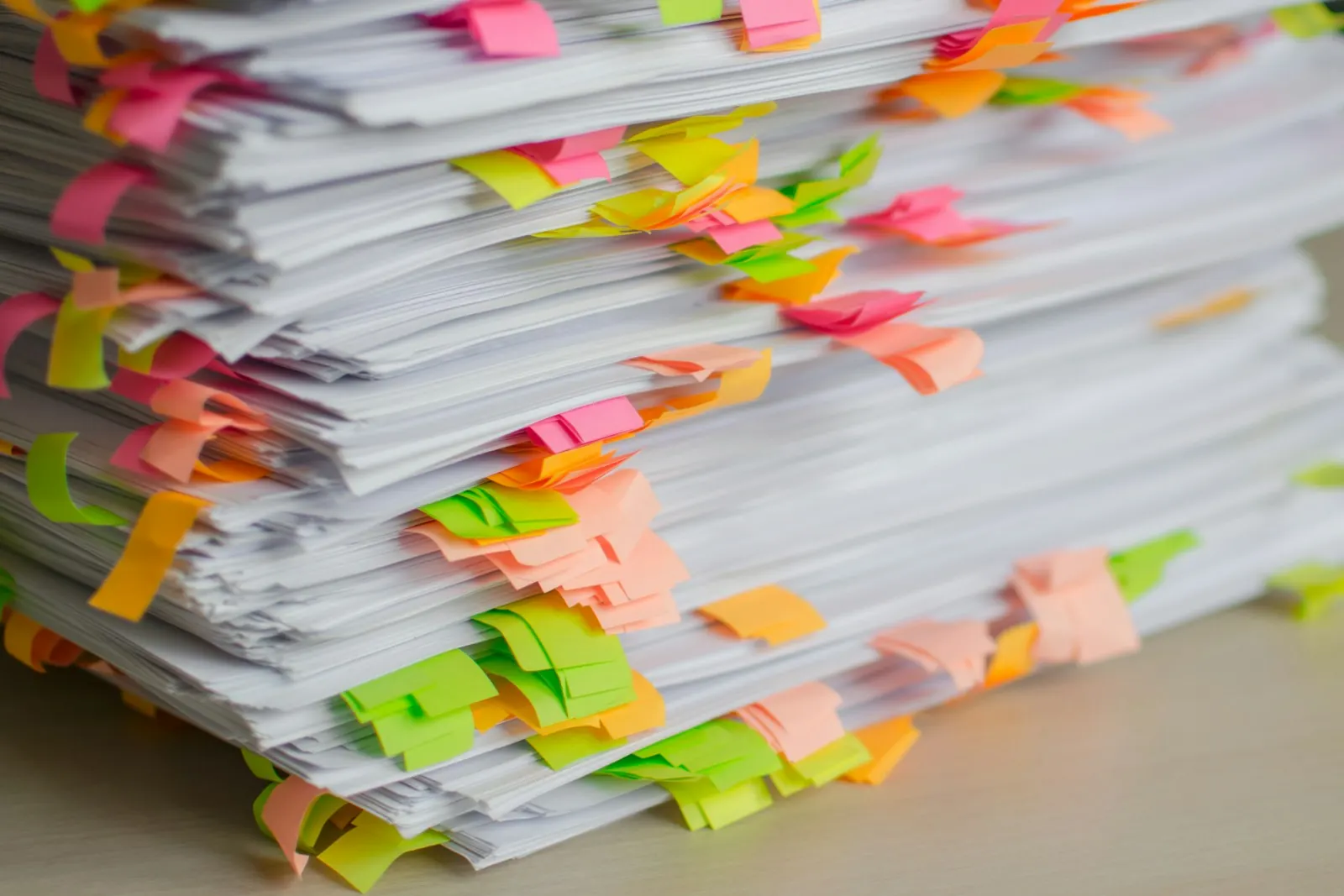 A stack of papers with colourful sticky tabs